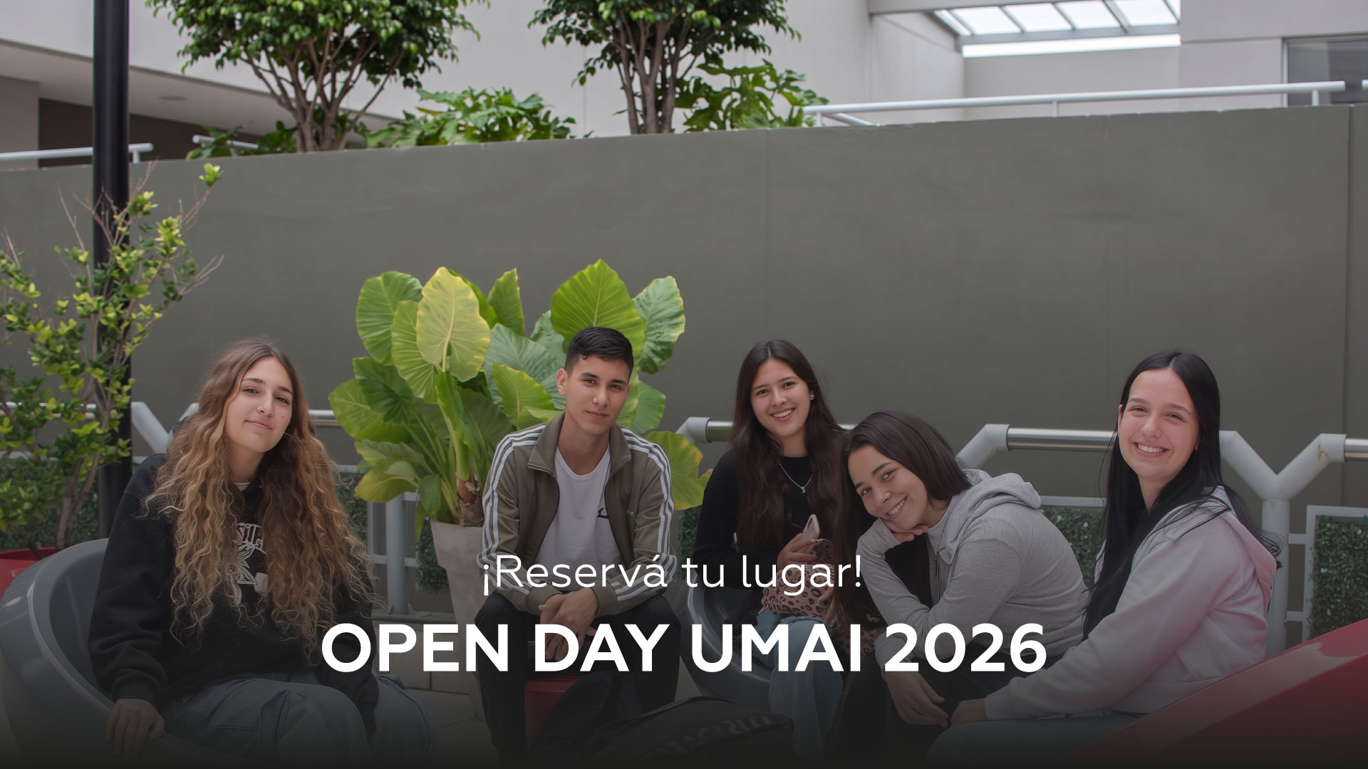 Five smiling students sit in a courtyard with large green leaves in the background; overlay text reads '¡Reservá tu lugar!' and 'OPEN DAY UMA 2026' for a promotional banner.