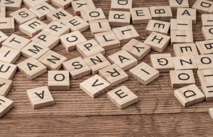 Scattered wooden Scrabble tiles with random letters on a rustic wooden table surface] , but ensure proper punctuation? Wait. Need proper JSON. Let's craft correctly.
